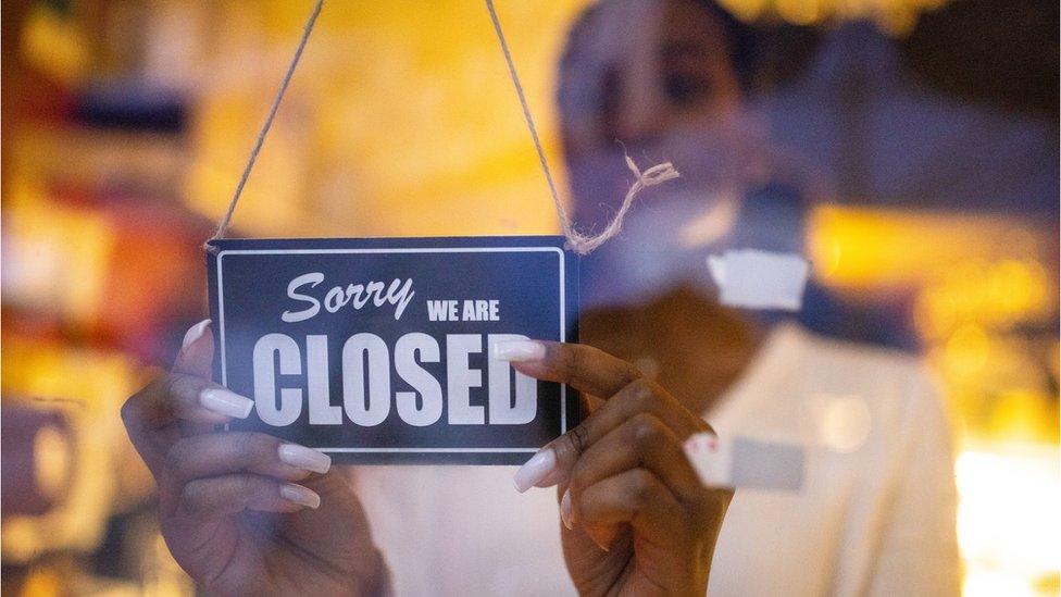 Woman with store closed sign