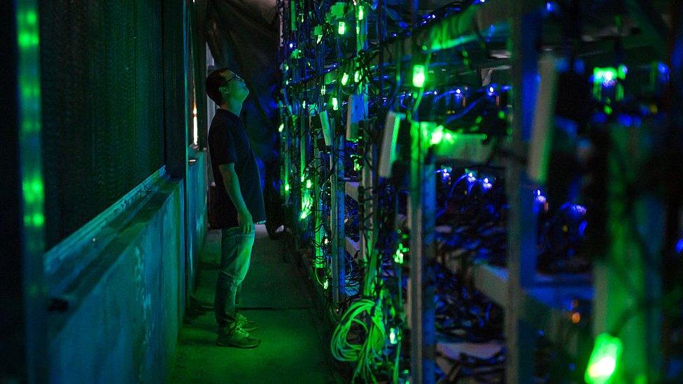 Man staring at CPUs in Chinese bitcoin mine.