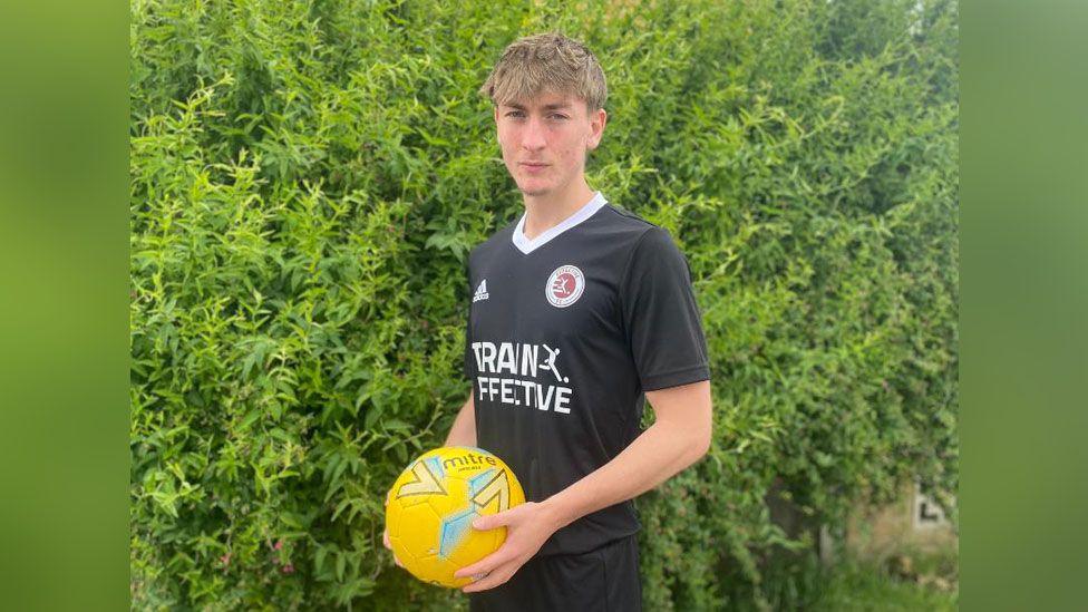 James Pope holding a yellow football 