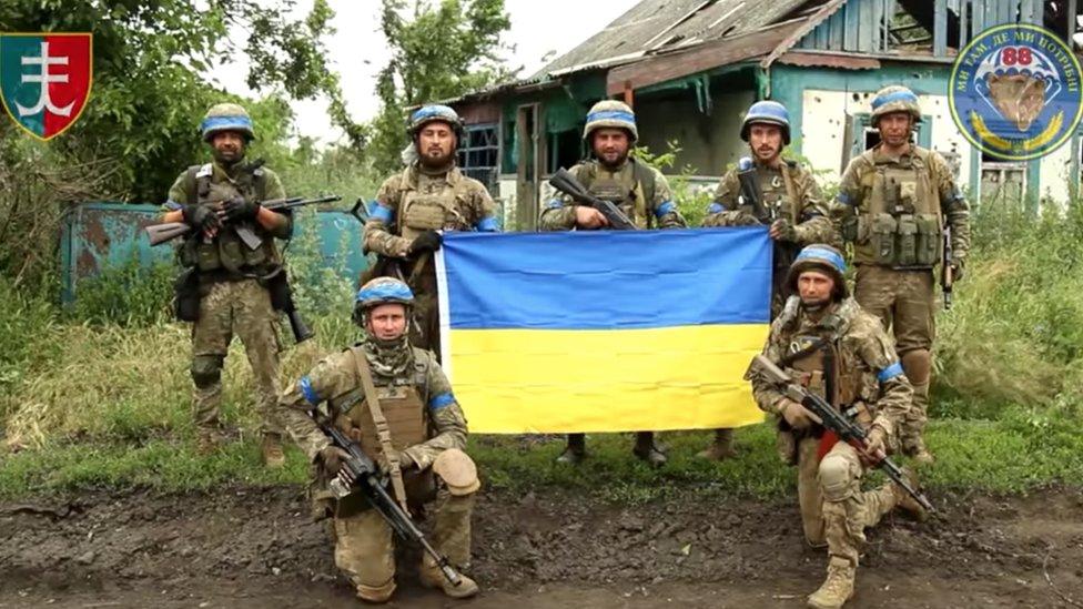 Photo purportedly showing Ukrainian soldiers with a national flag in the village of Storozheve, eastern Ukraine. Photo: 12 June 2023