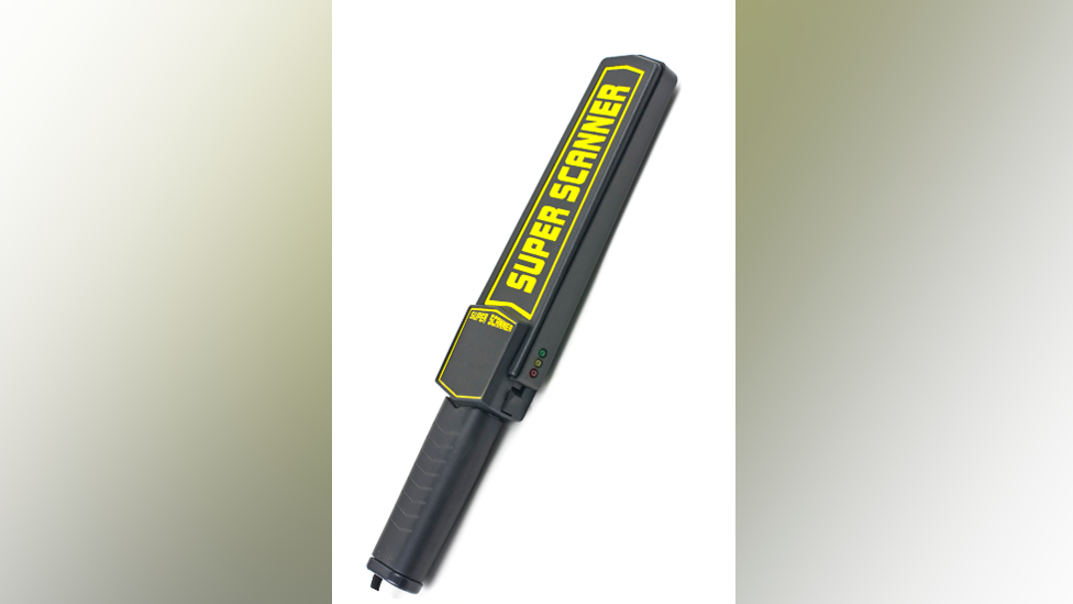 A black handheld metal detector which has the words Super Scanner written on it in bright yellow writing in capital letters 