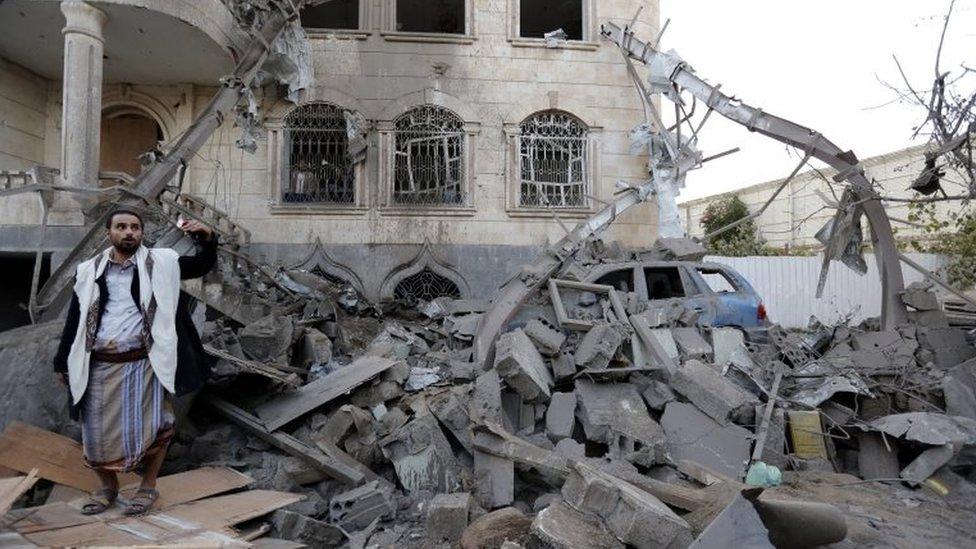 A man among rubble after an alleged Saudi-led airstrike in Yemen