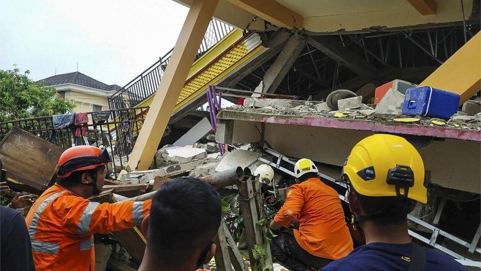 Rescue workers amid rubble