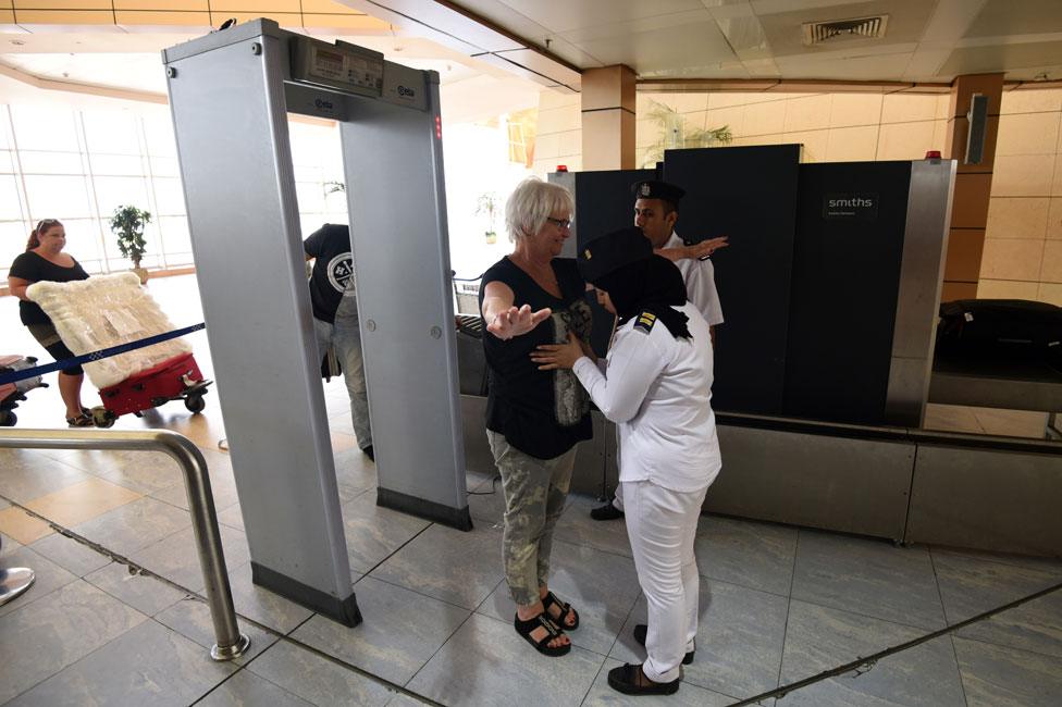 A woman is patted down at an Egyptian airport