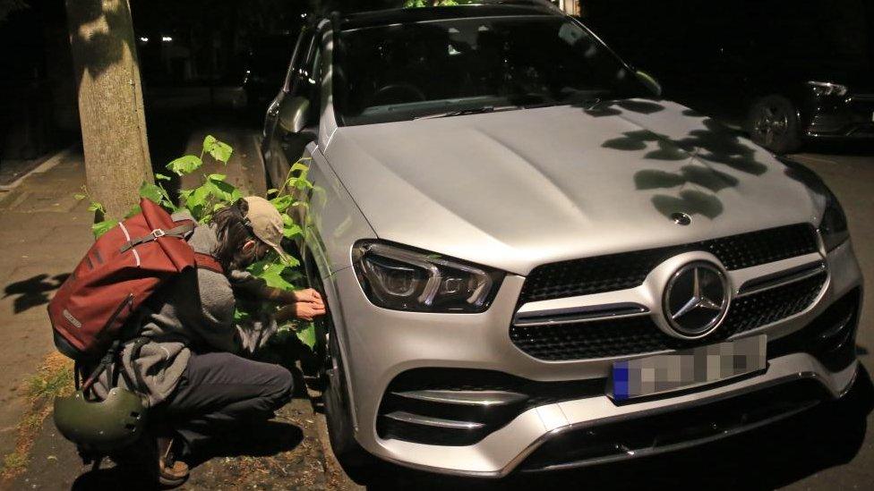 Man deflating tyre of a Mercedes car