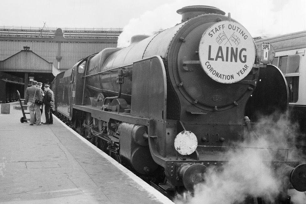 A train engine with a Laing sign on the front