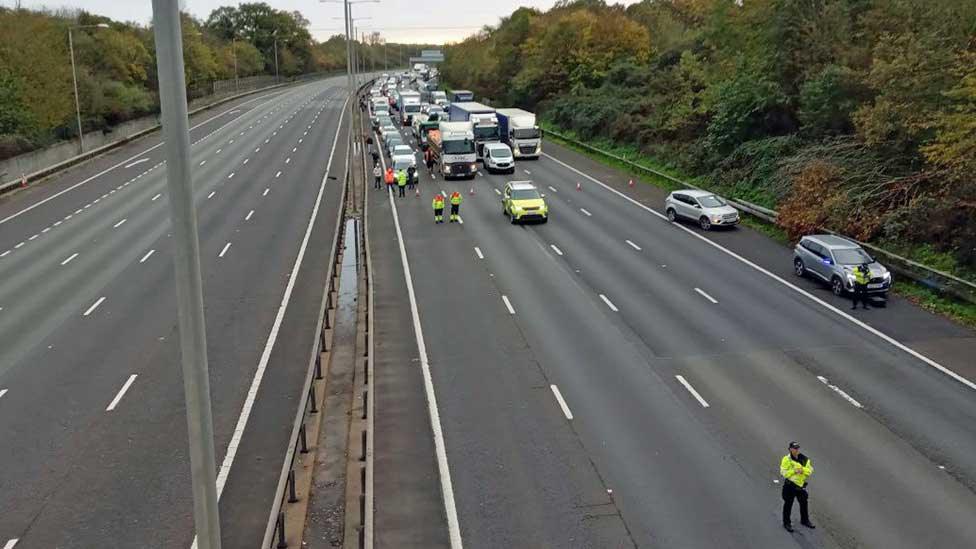 Carriageway of M25 closed as protesters climb gantries