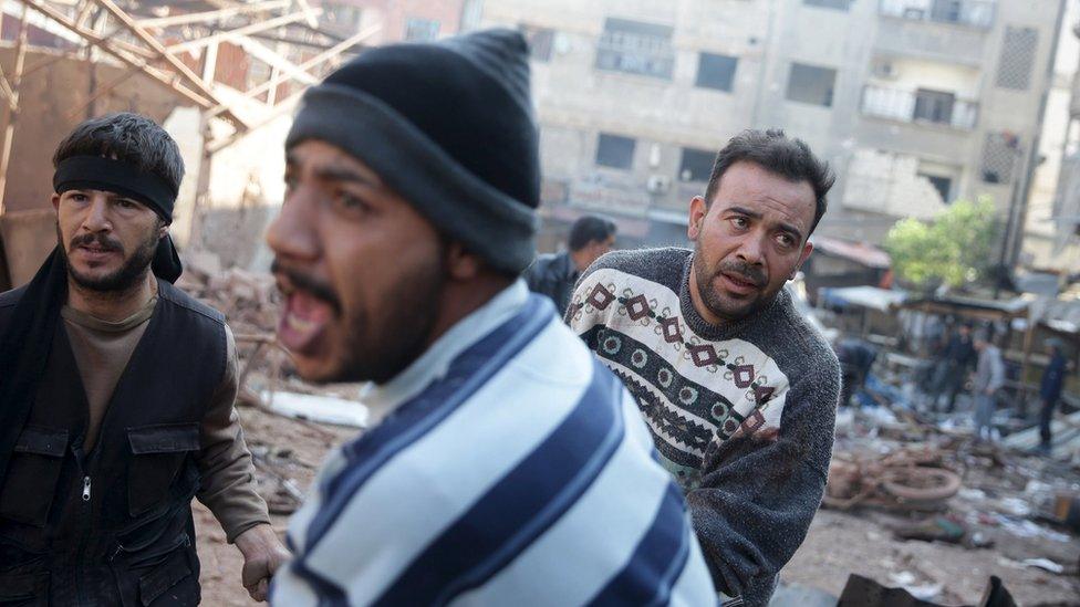 Men react as they carry the remains of dead people at a damaged site hit by missiles fired by Syrian government forces on a busy marketplace in the Douma neighbourhood of Damascus, Syria October 30, 2015.