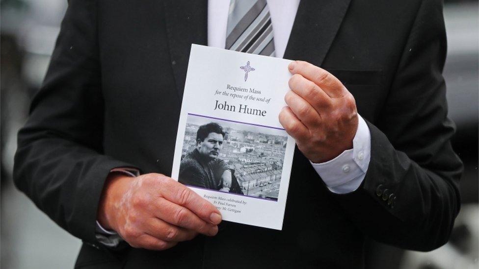 A mourner holds the order of service for the funeral Mass.