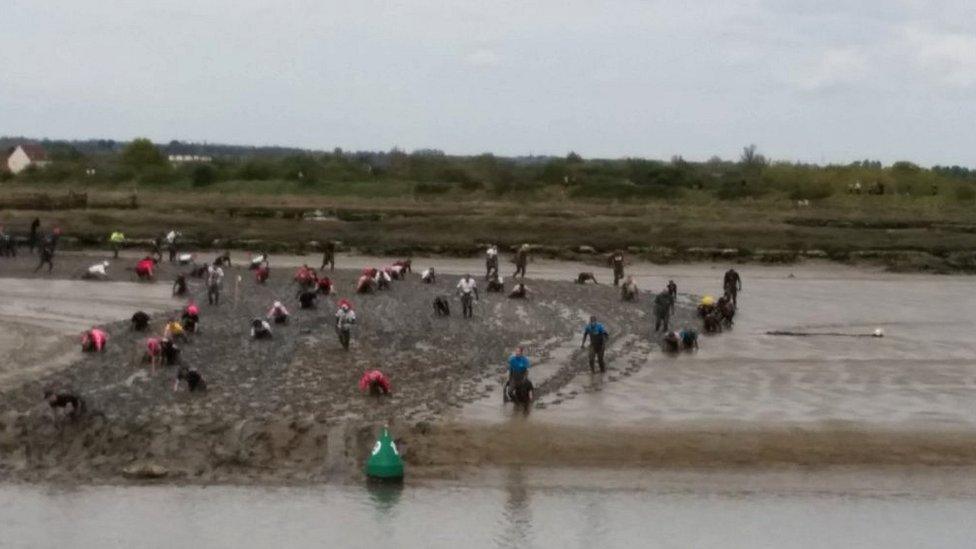 Competitors racing through thick mud