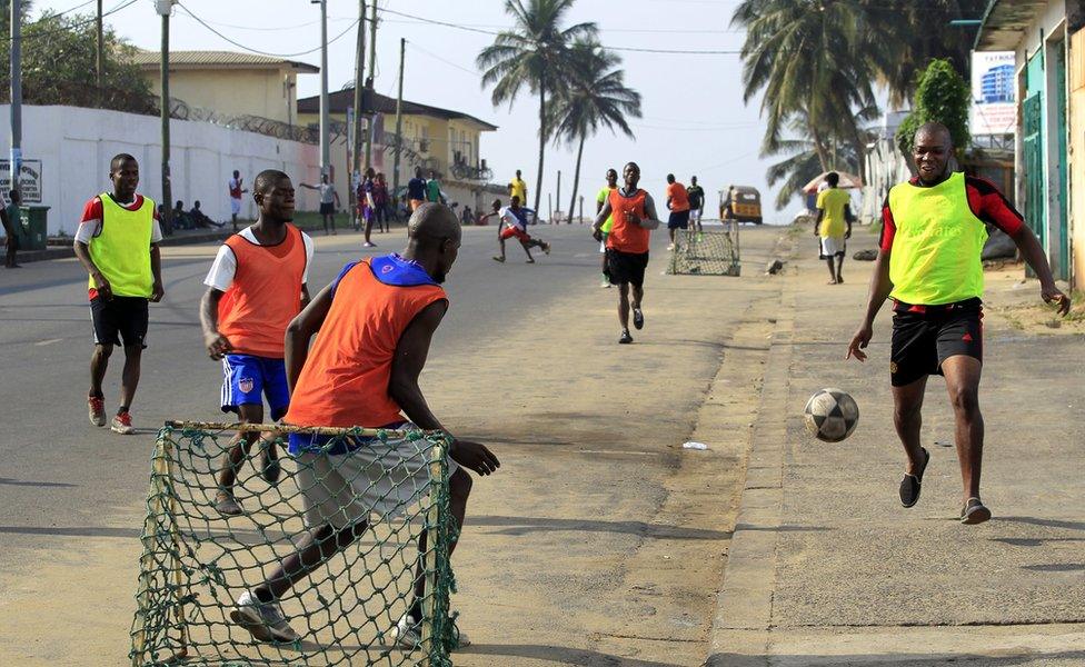 Footballers play a game on a street in central Monrovia, Liberia - Sunday 15 January 2017