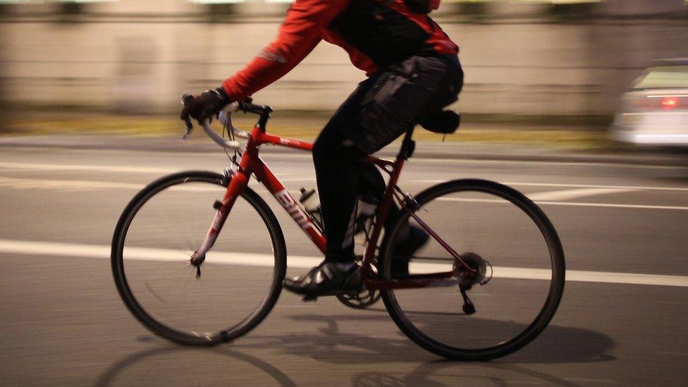 A cyclist in London at evening rush hour