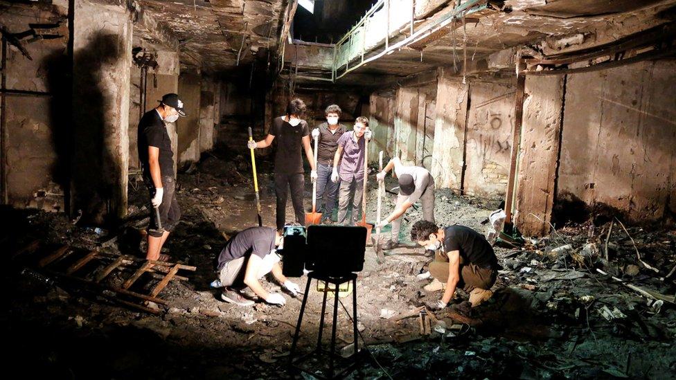 Workers clear up at the site of a bomb blast in Baghdad