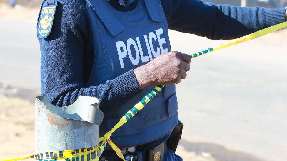 A police officer barricades a crime scene