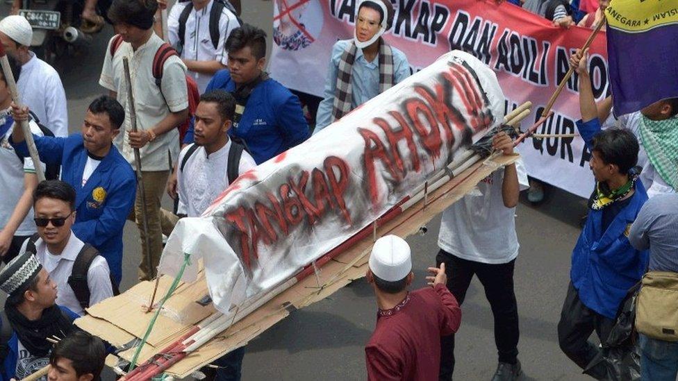 Indonesian Muslim students carry a mock coffin that reads: "Arrest Ahok", as Muslims march towards the presidential palace during a protest against Jakarta governor Basuki Tjahaja Purnama also known as Ahok over an alleged blasphemy in Jakarta on November 4, 2016.