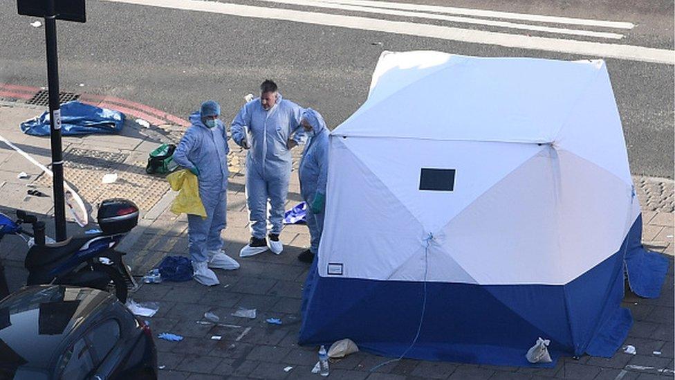 A forensics tent and officers at the scene