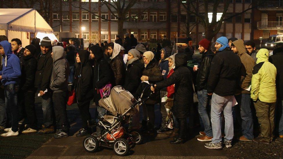 Migrants wait outside the Central Registration Office for Asylum Seekers in Berlin