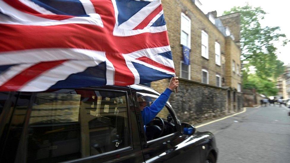 Taxi driver holding Union Jack flag