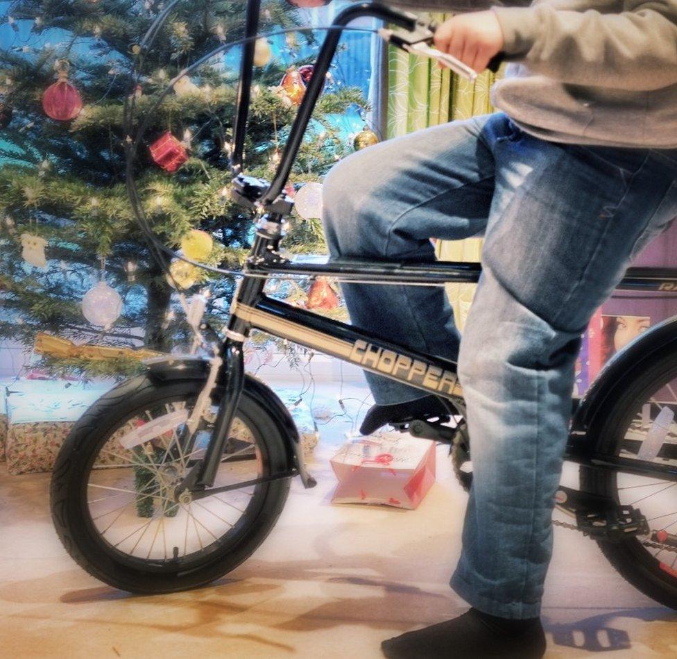 Boy sits on a new bike on Christmas day in Glasgow, Scotland