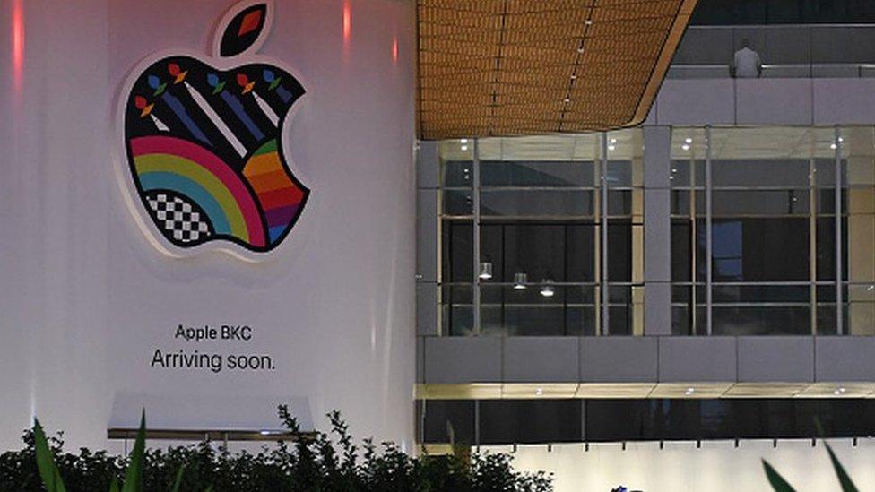 People are seen taking pictures of the soon-to-be launched Apple's first company-owned store in India inside the Jio World Drive mall at Bandra Kurla Complex (BKC) in Mumbai.