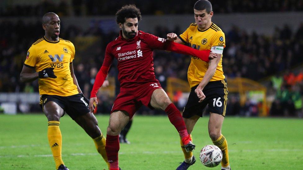 Mohamed Salah of Liverpool competes with Willy Boly and Conor Coady of Wolverhampton Wanderers during the Emirates FA Cup Third Round match between Wolverhampton Wanderers and Liverpool at Molineux