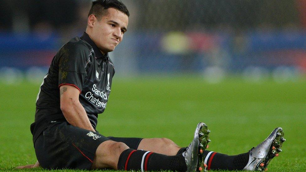 Philippe Coutinho of Liverpool reacts after going down with an injury during the Capital One Cup semi final,