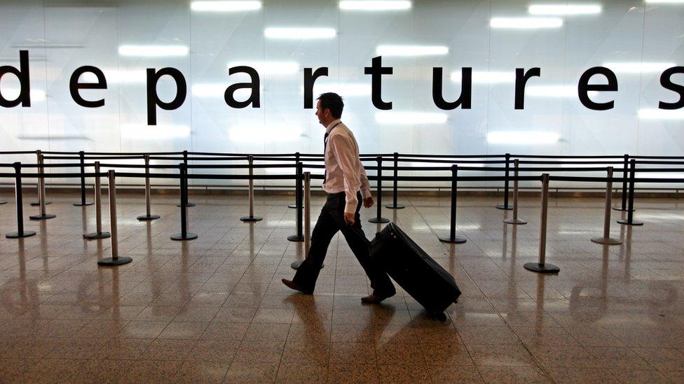 Man walking through airport departures