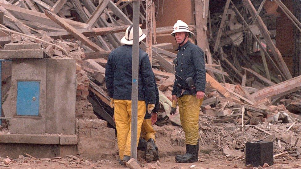 Fireman in front of rubble