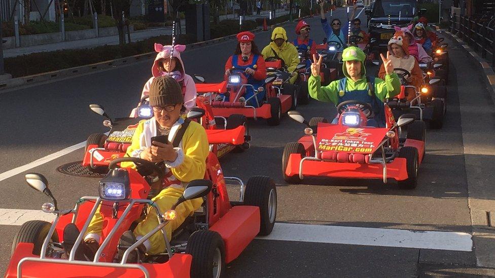 Drivers in Super Mario cosplay outfits drive kart on Tokyo public roads