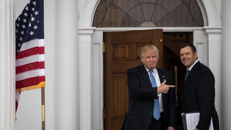 Trump stands next to Kris Kobach