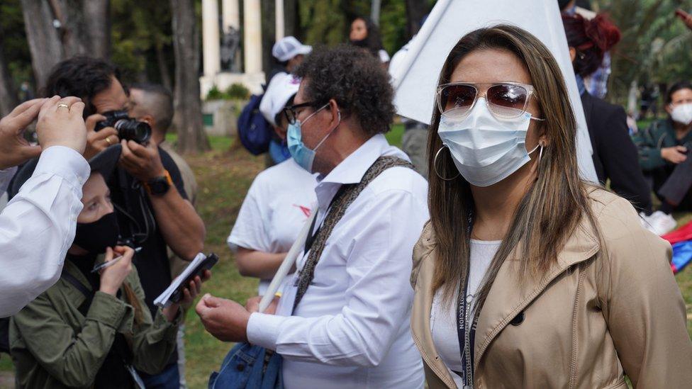 A bodyguard from Colombia's National Protection Unit watches over FARC party leader Pastor Alape, as he takes questions from journalists in Bogota, Colombia on Nov 1.