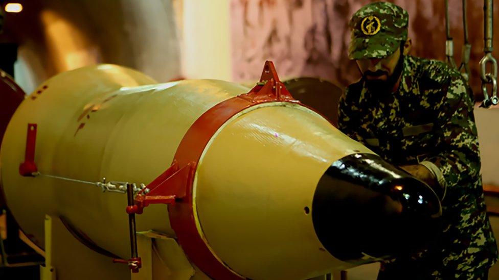 Member of the Revolutionary Guards next to a missile launcher in an underground tunnel at an undisclosed location in Iran