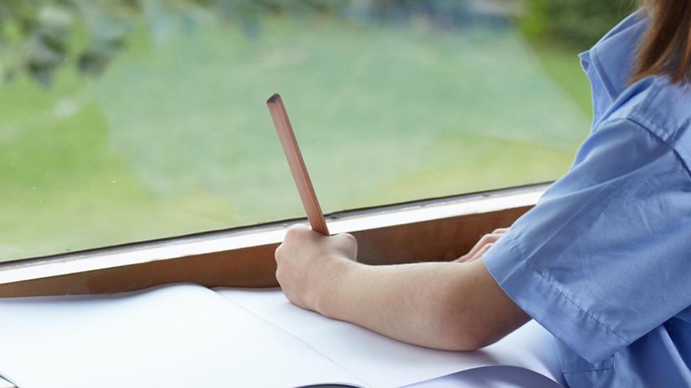 Girl writing on paper.