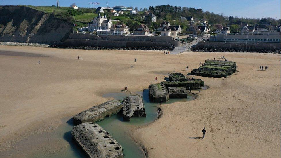 In this aerial view pontoons from the World War II Allied temporary Mulberry harbor built during the D-Day invasion lie on the beach on April 30, 2019 at Arromanches-les-Bains,