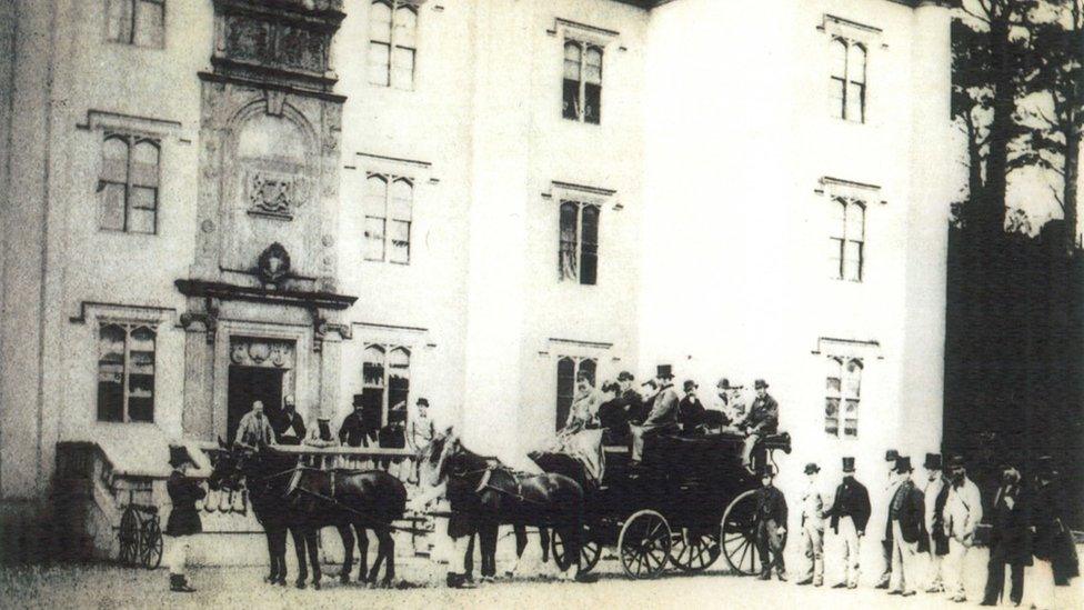 Black and white photograph of a horse-drawn coach party outside Antrim castle