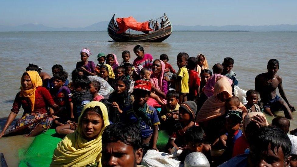 Rohingya refugees sit on a makeshift boat as they get interrogated by the Border Guard Bangladesh after crossing the Bangladesh-Myanmar border, at Shah Porir Dwip near Cox"s Bazar, Bangladesh