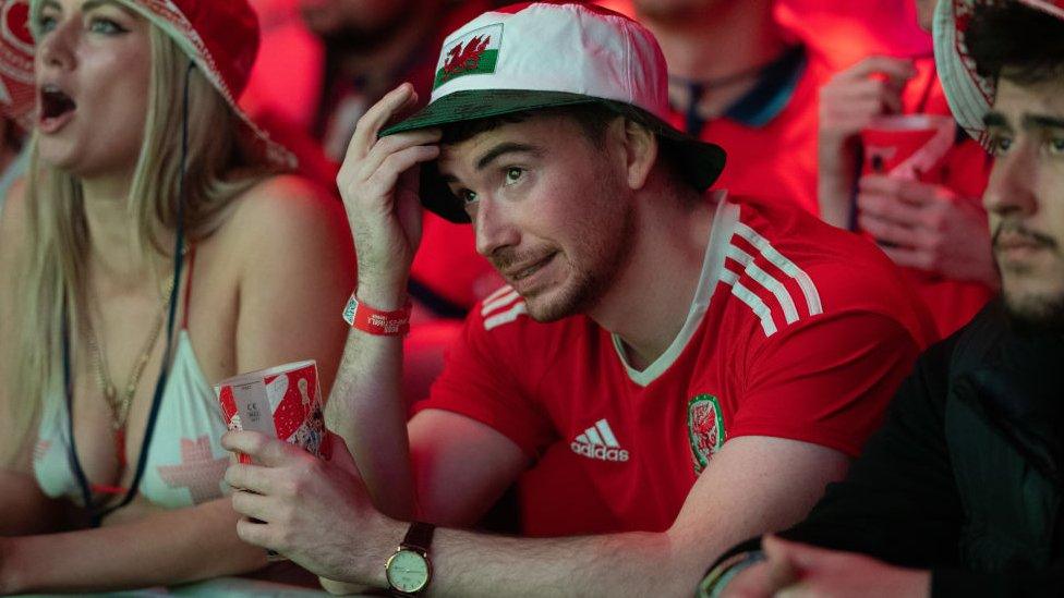 A Wales fan grimaces while watching England game