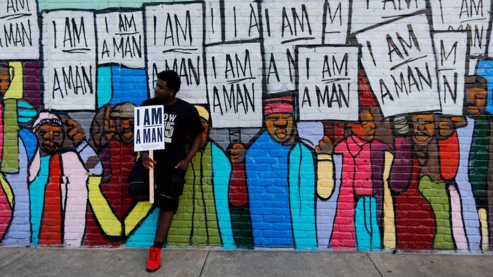 Xavier Hibler leans against a mural while marching through downtown during a Fight for $15 rally on April 4, 2017 in Memphis, Tennessee. About 1,000 people marched through downtown Memphis from City Hall to the National Civil Rights museum on the 49th anniversary of Dr. Martin Luther King, Jr.'s assassination