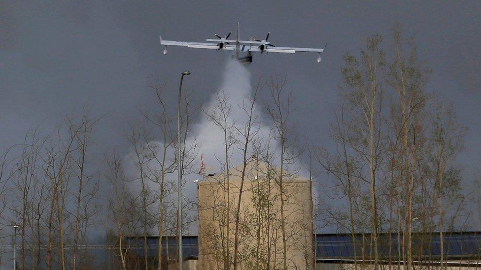 A plane dumps water on the wildfires near Fort McMurray, Alberta (07 May 2016)