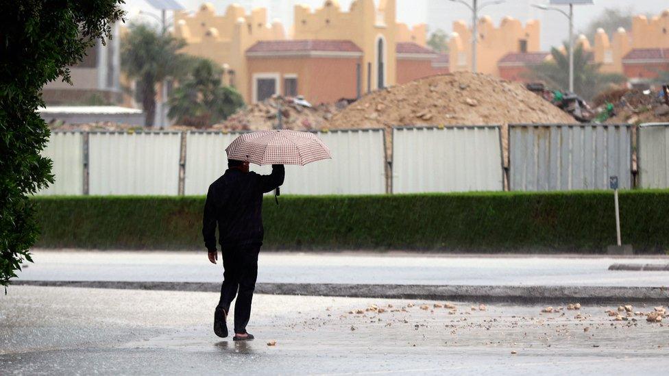 Man shelters from the heavy rain in Dubai