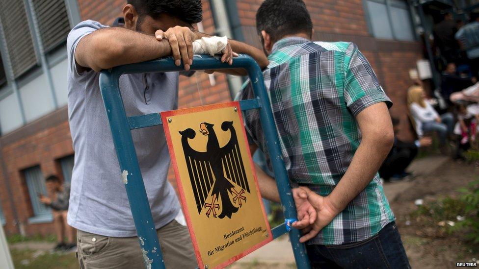 Asylum seekers wait in front of the Federal Office for Migration and Refugees (BAMF) in Berlin's Spandau district, Germany (17 August 2015)