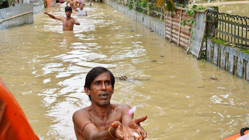 Man waits for medical supplies in flood waters