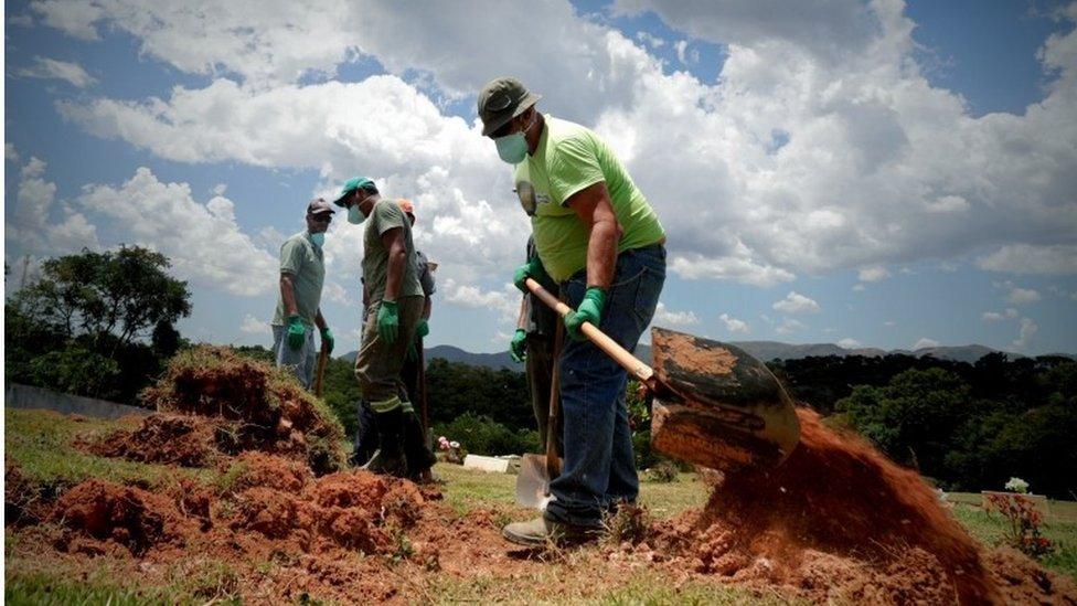 Men dig pits to bury victims of the dam accident