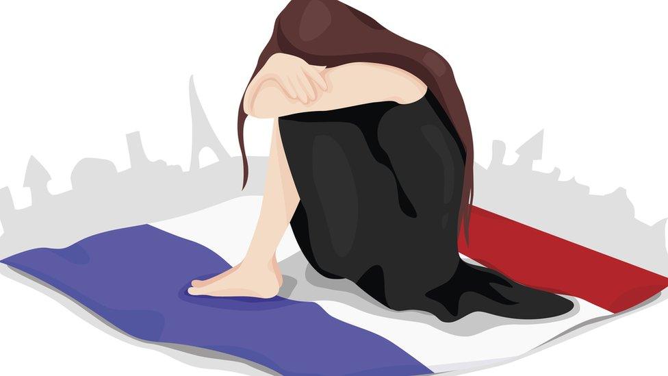 A woman crying over a French flag