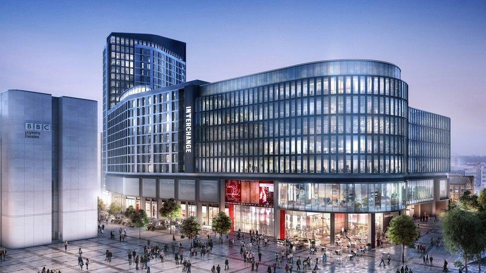 An artist's impression of the bus station and square including a glass building and tower beside a tiled piazza and the concrete BBC Cymru Wales building. 