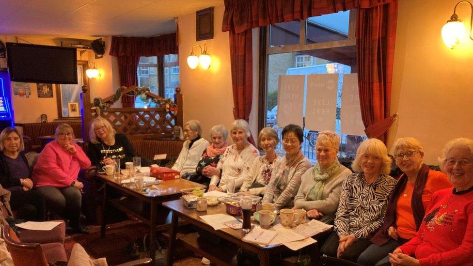 Dementia support group sitting at tables in the Windemere club