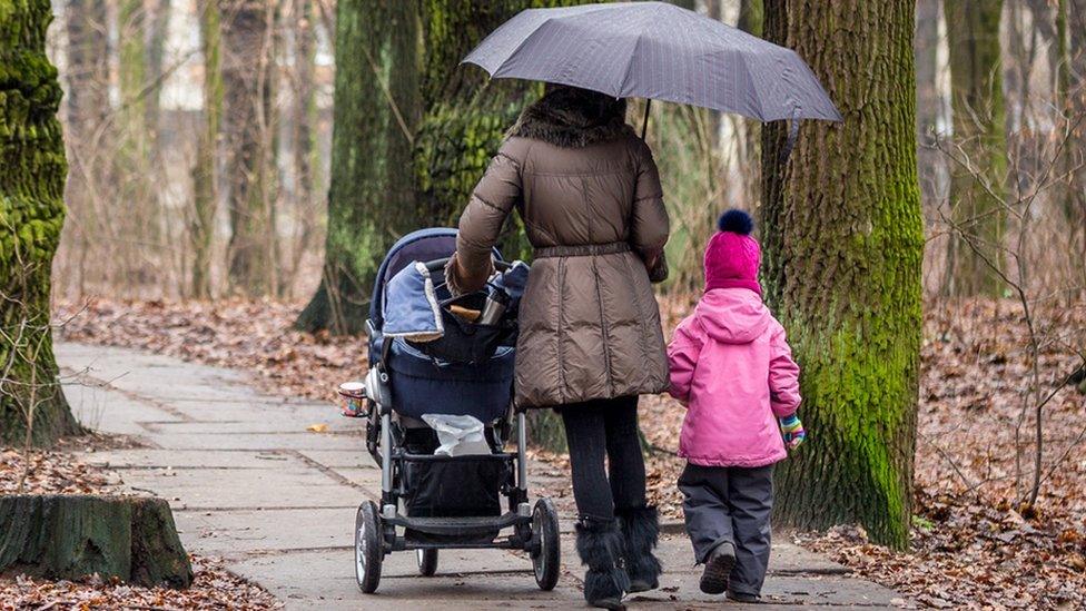 Woman walking with two children