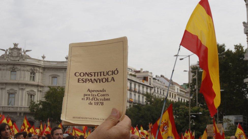 Opponent of independence holds a copy of the Spanish Constitution