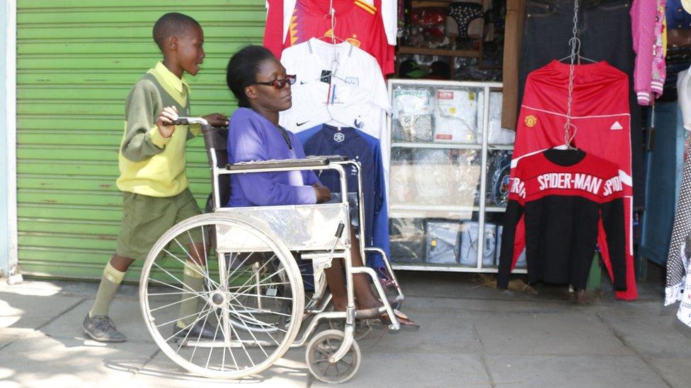 Irene Kerubo with her 10-year-old son Kevin Momanyi, a pupil at Bridge International Academies, who wheels her to her shop every morning before dashing to school