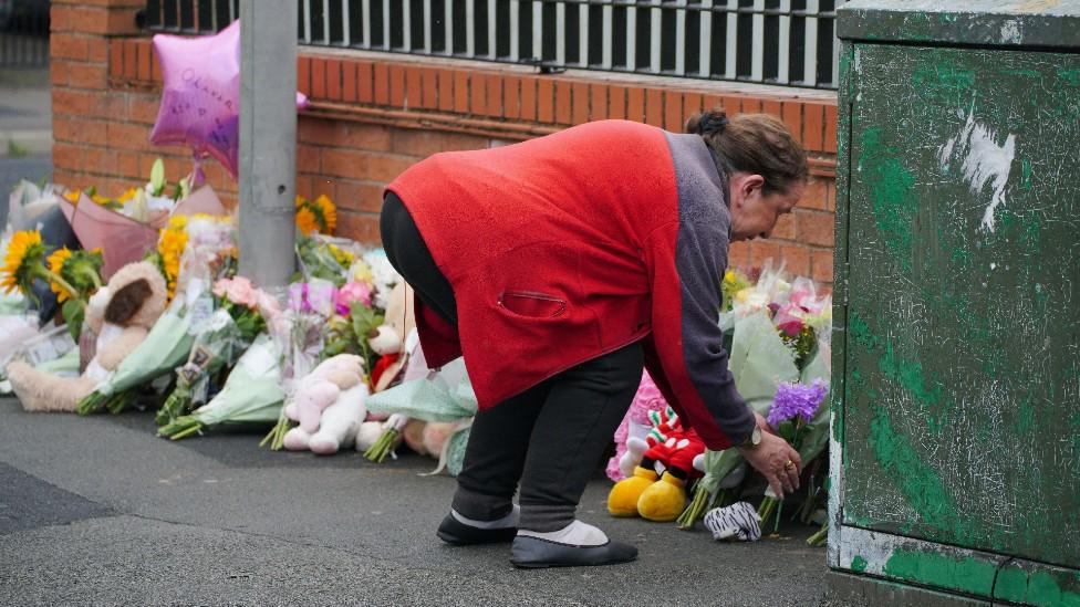 Woman leaving flowers for Olivia Pratt-Korbel